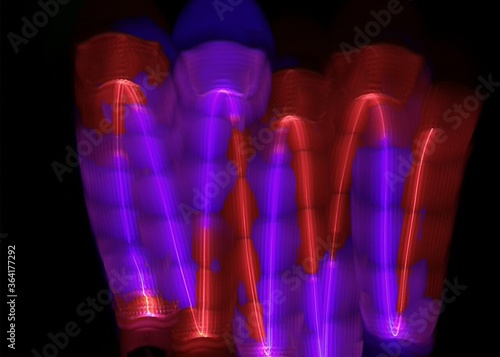 light painting abstract background. curves and waves of purple and red light against a black background