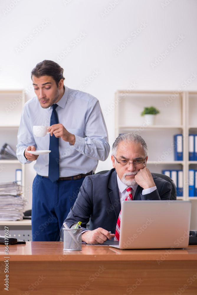 Old boss and young male employee in the office Old boss and young male employee in the office