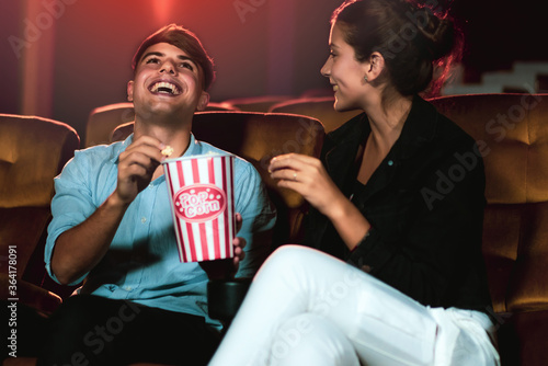 Man and woman watching movie in the movie theater cinema. Group recreation activity and entertainment concept. photo