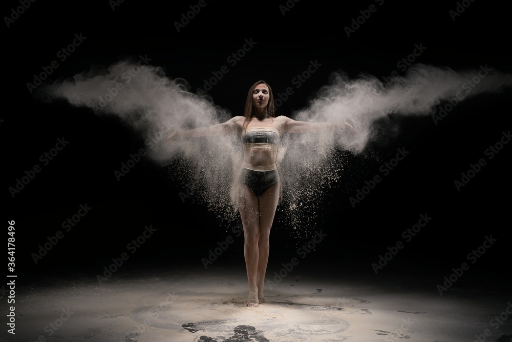 Brunette woman in sportswear throwing sand in air