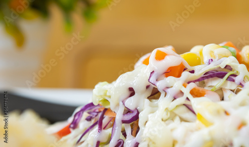 Vegan Salad with Mayonnaise Topping in Close Up View include Carrot and Tomato and Corn and Cabbage and Peas and Lettuce on Right Frame