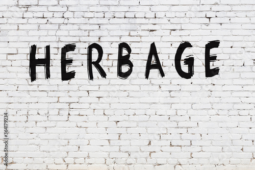 White wall with black paint inscription herbage on it