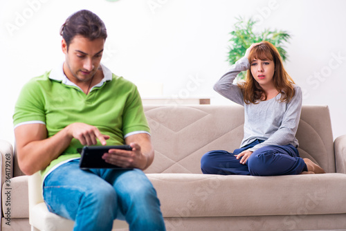 Young couple in gadget dependency concept