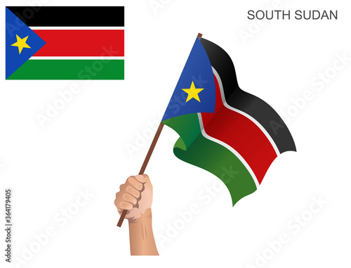 Flag of the State of South Sudan raised with a stick held by hand to inflame the spirit of statehood
