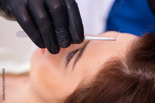 Young woman visiting male beautician in hair transplantation con