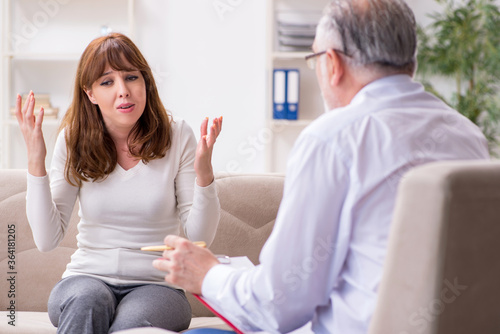 Young woman visiting old male doctor psychologist