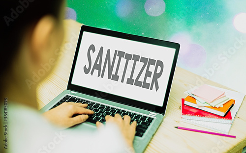 Conceptual hand writing showing Sanitizer. Concept meaning liquid or gel generally used to decrease infectious agents Modern gadgets white screen under colorful bokeh background photo