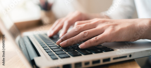 Close up hands of woman using laptop computer working and searching online information with blurry background. copy space of technology business and social distancing concept. Panoramic banner portion