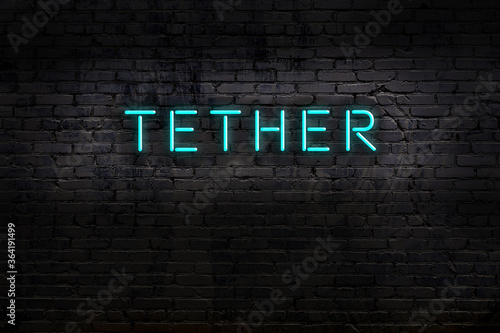 Neon sign. Word tether against brick wall. Night view