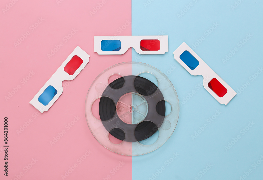 Film reel and anaglyph 3D glasses on pink blue background. Entertainment industry. Cinema. Top view Film reel and anaglyph 3D glasses on pink blue background. Entertainment industry. Cinema. Top view