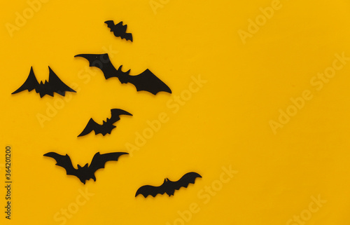 Halloween background, decorations and scary concept. Black bats fly over yellow background, Copy space