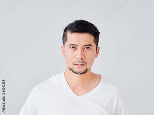 Handsome young man on grey background. © jittima