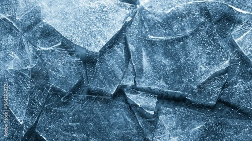 Close-up of melting ice texture. Studio shot close-up of the blue surface of cracked melting ice in time lapse.