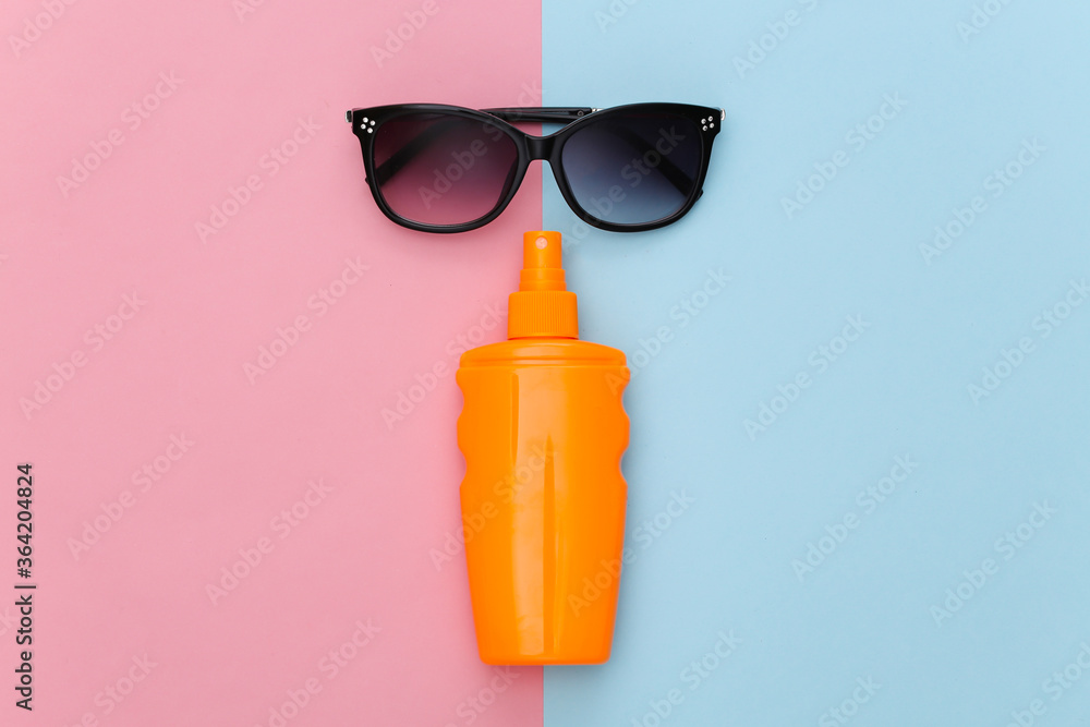 Beach vacation. Sunblock bottle and sunglasses on pink blue background. Top view. Flat lay Beach vacation. Sunblock bottle and sunglasses on pink blue background. Top view. Flat lay