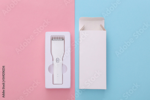 New Wireless Hair Clipper in packaging on pink blue pastel background. Top view
