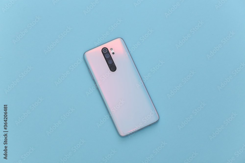 Modern smartphone back with lenses on a blue background. Top view Modern smartphone back with lenses on a blue background. Top view