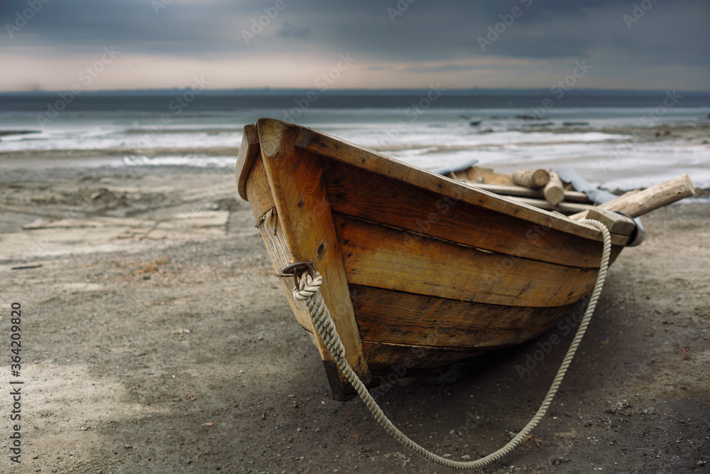 Old fishing wooden boat on the shore.