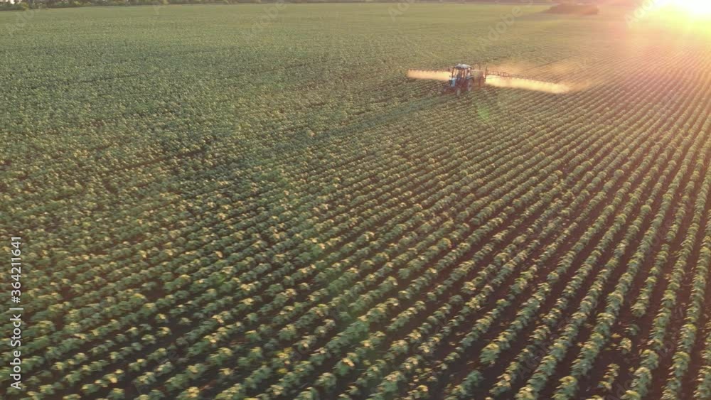Aerial view of farming tractor spraying on field with sprayer ...