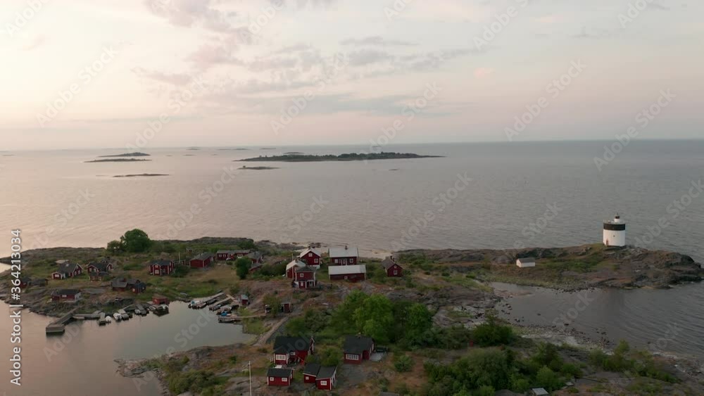 Aerial view of island with houses & lighthouse during dusk sunset Aerial view of island with houses & lighthouse during dusk sunset