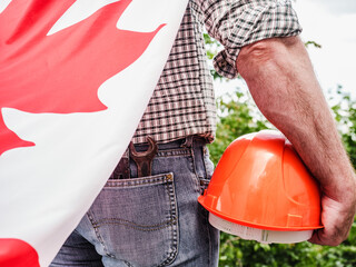 Handsome man with tools, holding an American Flag. View from the back, close-up. Concept of work and employment