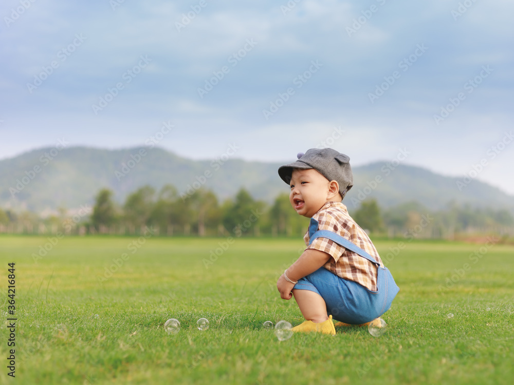 Fototapeta premium Asian toddler boy playing in nature park