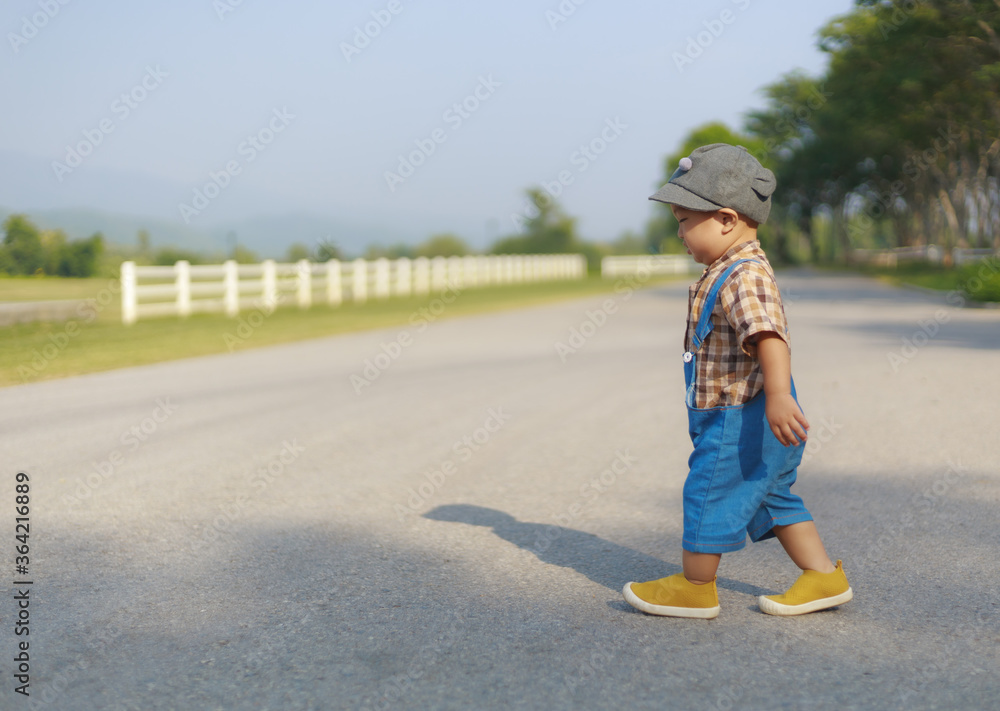 Fototapeta premium Asian toddler boy walking lonely