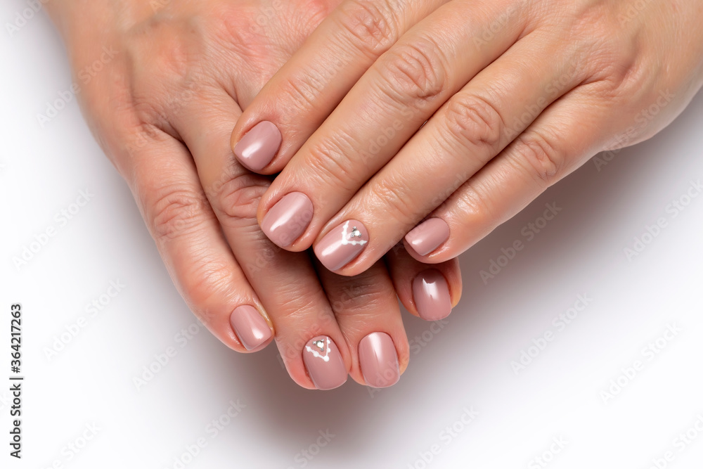 beige manicure on short nails with crystal and dots on nameless nails closeup n white background beige manicure on short nails with crystal and dots on nameless nails closeup n white background