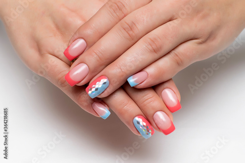 Peach  coral blue french manicure with silver rhombus on long square nails closeup 