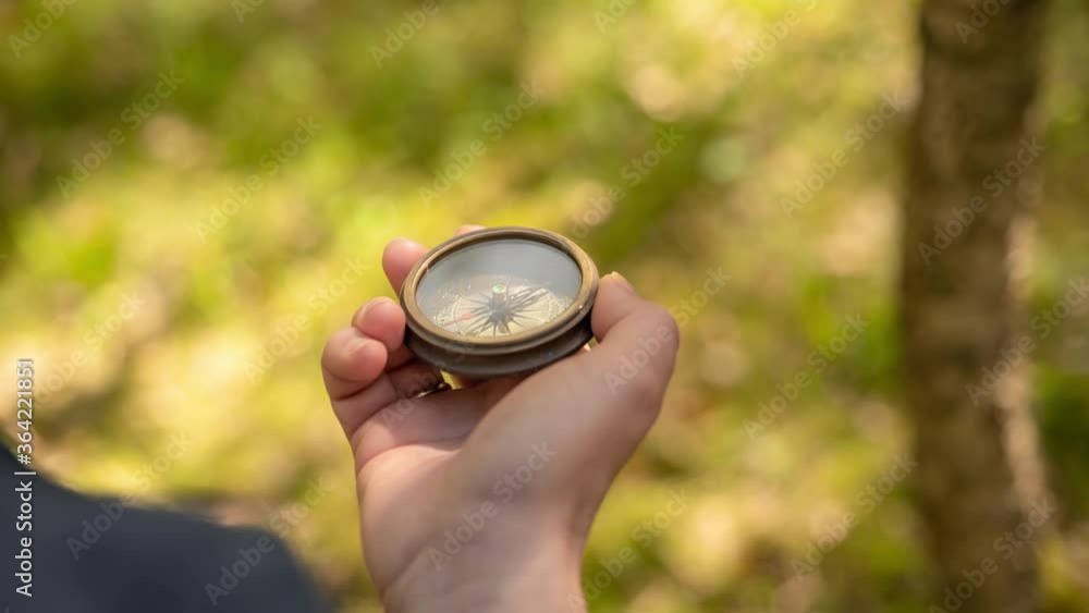 Traveler hand holds a compass in forest Traveler hand holds a compass in forest