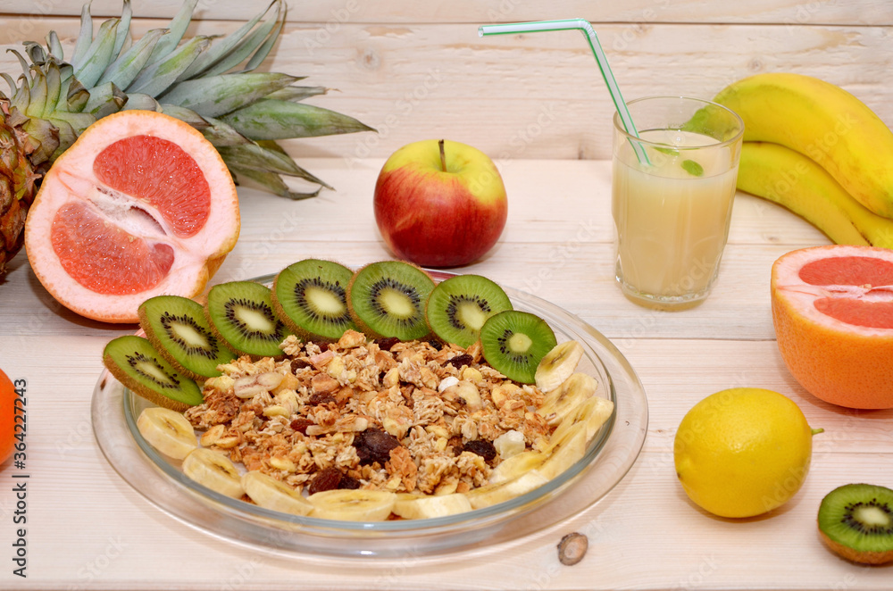 healthy breakfast with muesli and fruits and a glass of juice on a wooden background healthy breakfast with muesli and fruits and a glass of juice on a wooden background