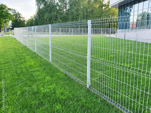 grating wire industrial fence panels, pvc metal fence panel and neatly trimmed lawn. © Анастасия Бурлакова