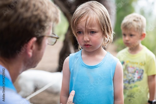 Parent disciplining and talking to his kid.