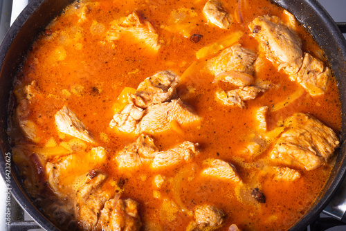 Cooking chicken with spicy sauce, Italian cuisine - Arrabbiata garlic chicken is cooked in a pan, close-up