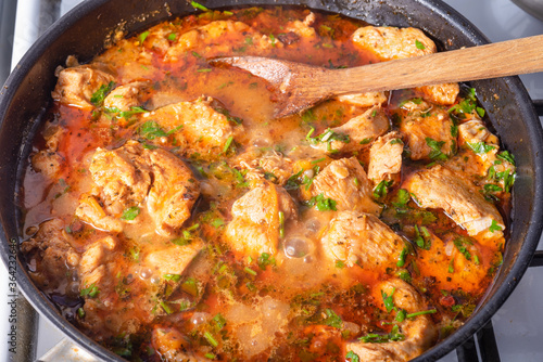 Cooking chicken with spicy sauce, Italian cuisine - Arrabbiata garlic chicken with parsley is cooked in a pan, close-up