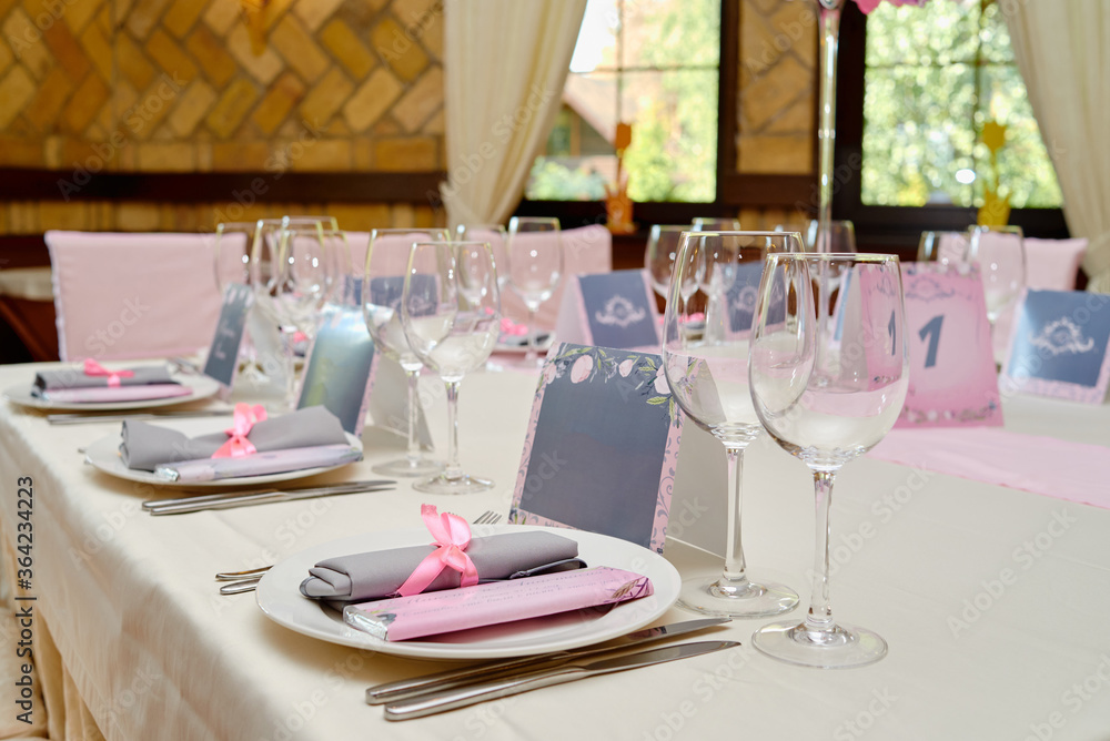 Table set with blank guest card, plate with white napkin and cutlery on table, copy space. Place setting at wedding reception. Table served for wedding banquet in restaurant Table set with blank guest card, plate with white napkin and cutlery on table, copy space. Place setting at wedding reception. Table served for wedding banquet in restaurant