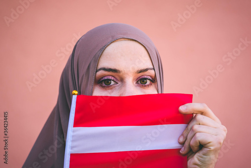 Canvas Print Muslim woman in a scarf holds flag of Austria