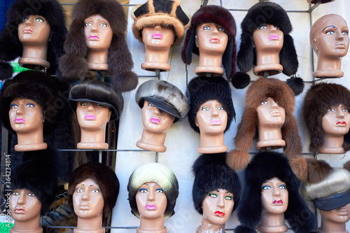 Variety of female winter fur hats on mannequin heads
