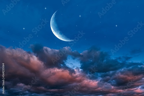 a young month in the clouds. night landscape sky