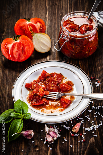 Raw tomatoes and sun dried tomatoes in olive in jar