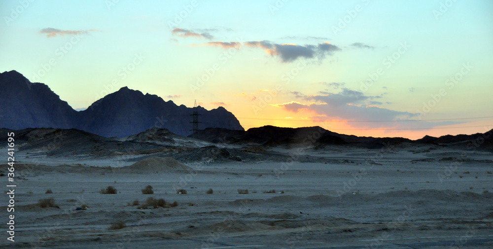 Panorama of sunrise in the arabian desert. Early morning in Egypt. The view from the window of a tourist bus on the road to Luxor.