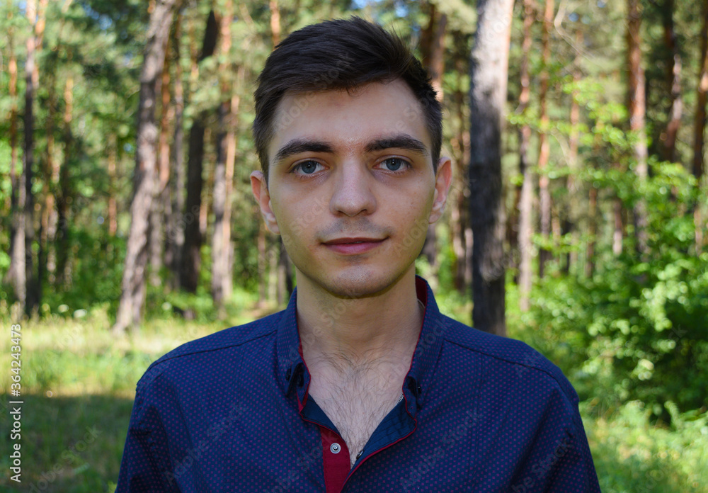 Portrait of a young handsome brunet man in shirt on forest background Portrait of a young handsome brunet man in shirt on forest background