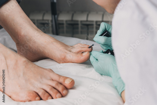 Young woman getting professional pedicure in beauty salon