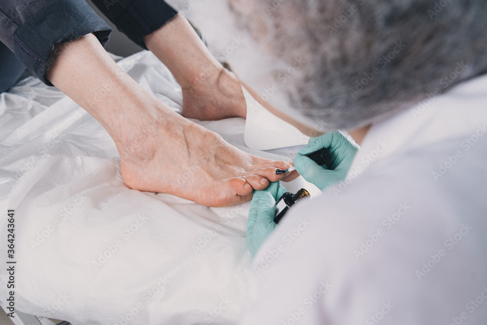 Fototapeta premium Young woman getting professional pedicure in beauty salon