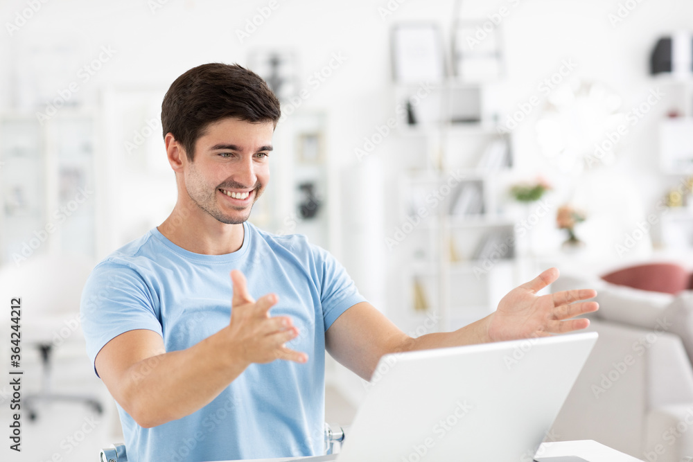 Happy millennial man, enjoying watching educational webinar on laptop or have friendly meeting video call at home office studio. Happy millennial man, enjoying watching educational webinar on laptop or have friendly meeting video call at home office studio.