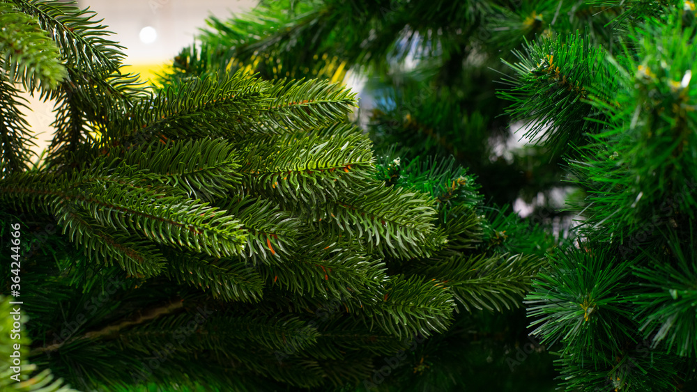 Artificial Christmas tree, green spruce branch with thin plastic needles, close-up background backdrop wallpaper design. Eco-friendly fake New Year spruce green color Artificial Christmas tree, green spruce branch with thin plastic needles, close-up background backdrop wallpaper design. Eco-friendly fake New Year spruce green color