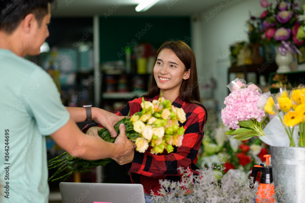 young woman small business florist arranging plants in flower shop
