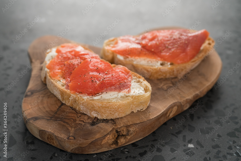 Sandwich with smoked salmon and cream cheese on olive woob board Sandwich with smoked salmon and cream cheese on olive woob board