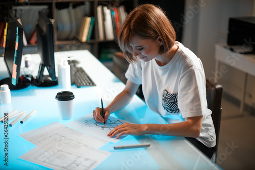 Young pretty creative woman designer is developing a new project, workspace in a creative company