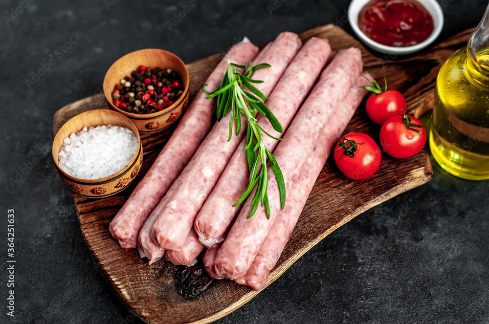 
Thin raw meat sausages on a stone background