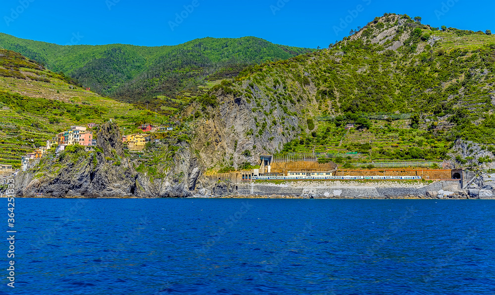 A view from the sea towards the railway station for the Cinque Terre village of Manarola, Italy in the summertime